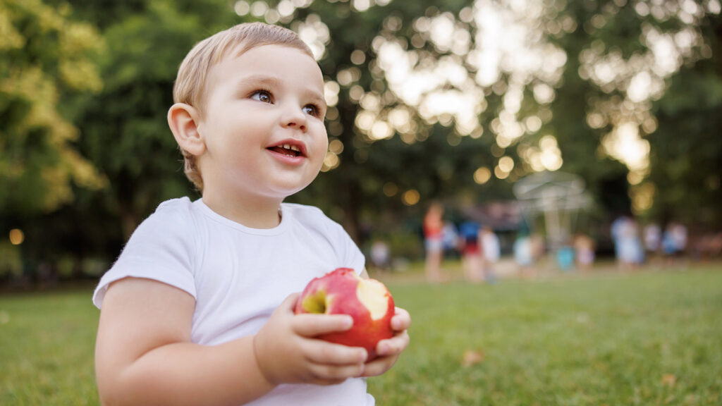 Portrait Kind Apfel essend Creche Und Findet